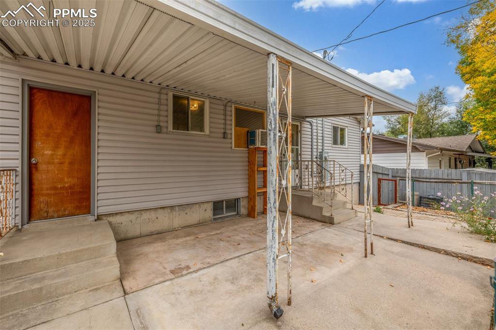 Image 26 of 36: Covered back patio with exterior door to attached garage and back door to k