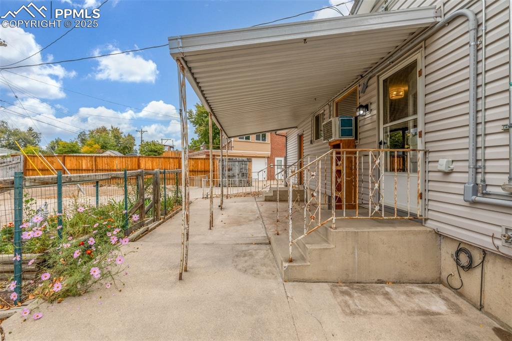Image 27 of 36: Fenced backyard with a covered patio