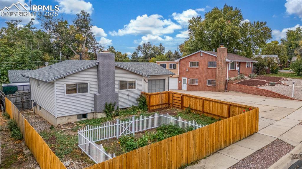 Image 28 of 36: Fully fenced front yard with perennials and vegetable garden - ready for th