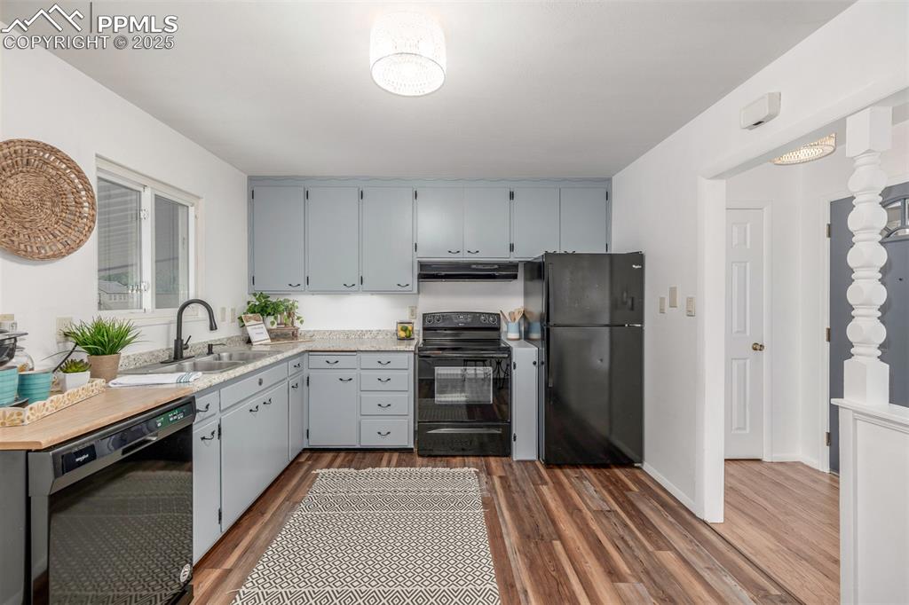 Image 6 of 36: Kitchen featuring newer vinyl plank floring, new countertop and black matte