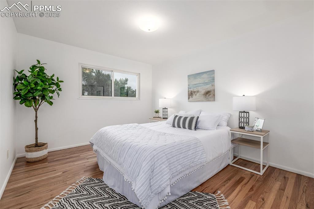 Image 9 of 36: Primary bedroom with newly refinished hardwood floors and gorgeous natural