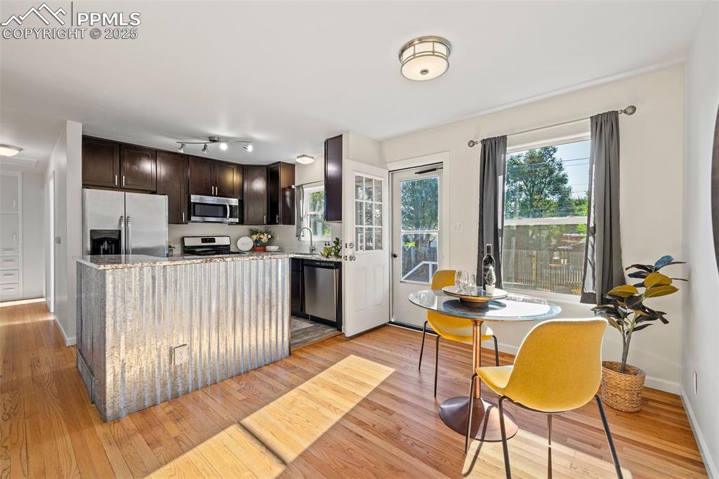 Image 11 of 39: Kitchen featuring appliances with stainless steel finishes, dark brown cabi