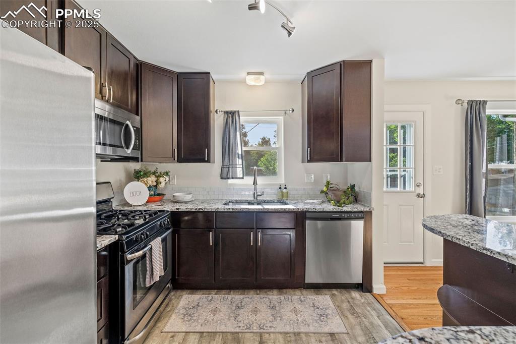 Image 15 of 39: Kitchen featuring stainless steel appliances, light wood-style flooring, da