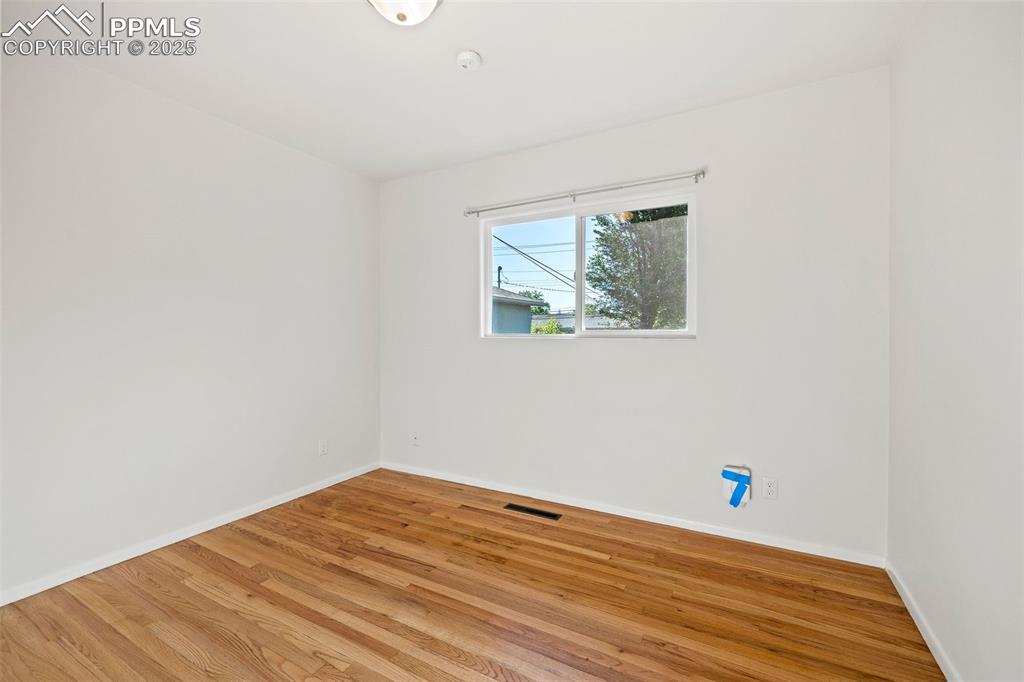 Image 20 of 39: Spare room with light wood-type flooring and baseboards