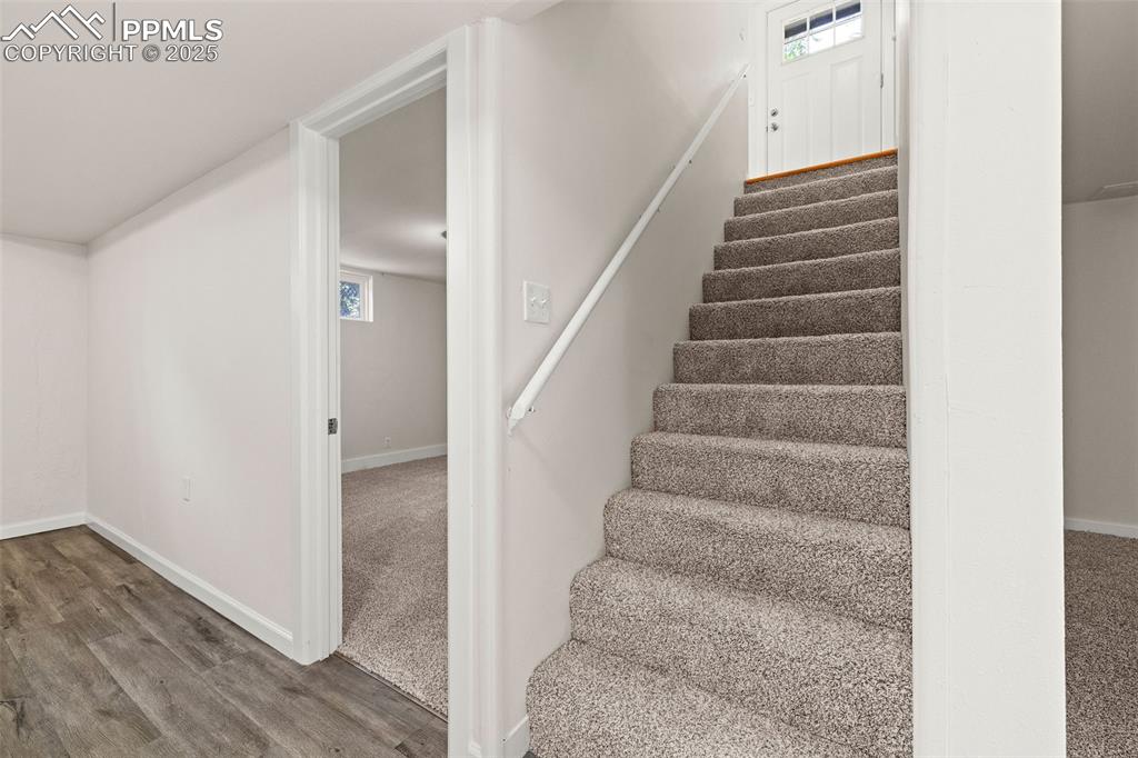 Image 22 of 39: Stairs with baseboards and wood finished floors
