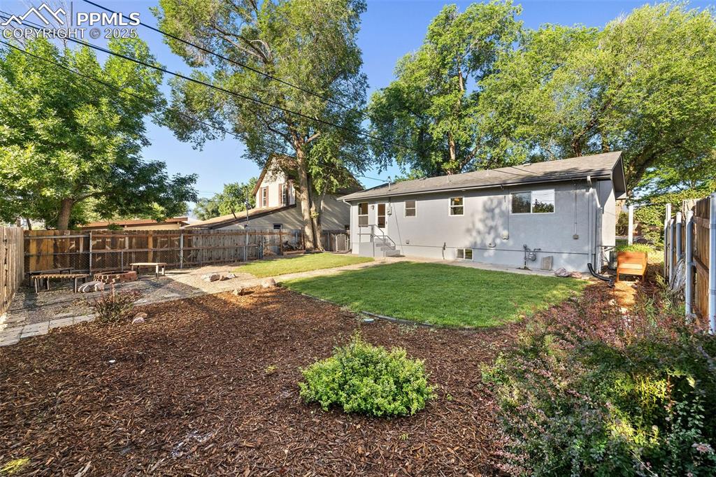 Image 33 of 39: Rear view of property featuring a fenced backyard and roof with shingles