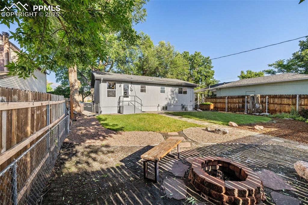 Image 36 of 39: Back of property with a fire pit and a fenced backyard