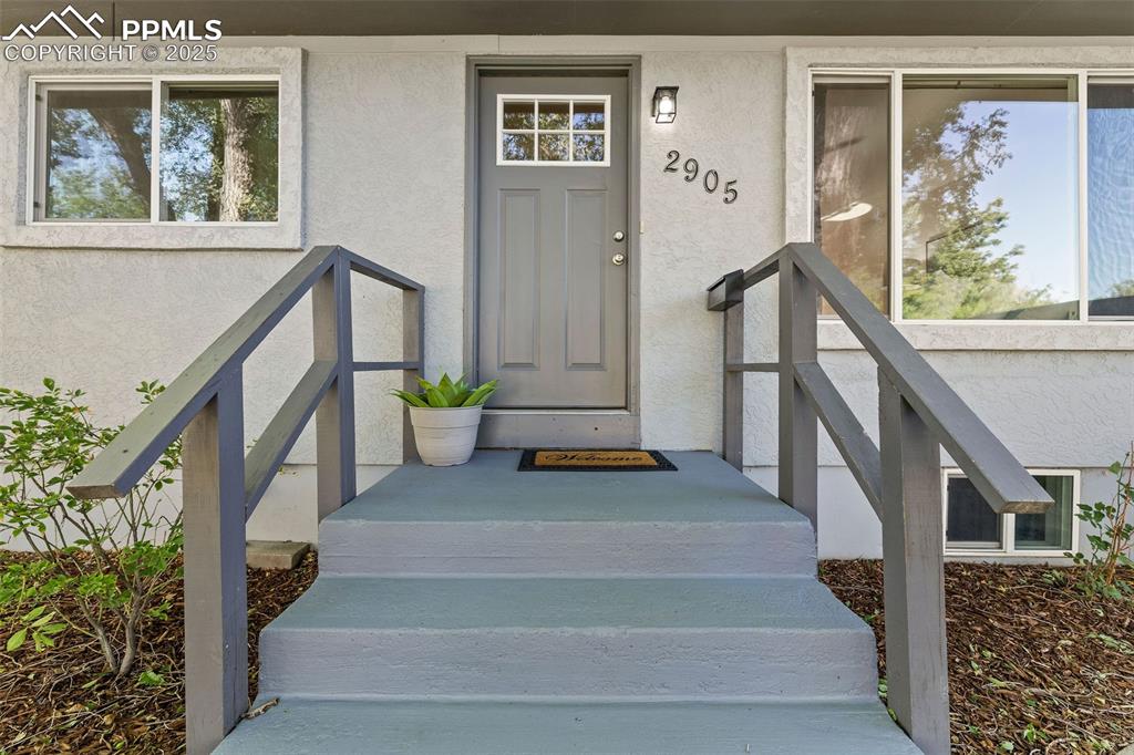 Image 4 of 39: Entrance to property with stucco siding