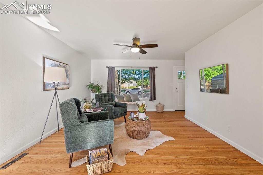 Image 8 of 39: Living area featuring a ceiling fan and light wood finished floors