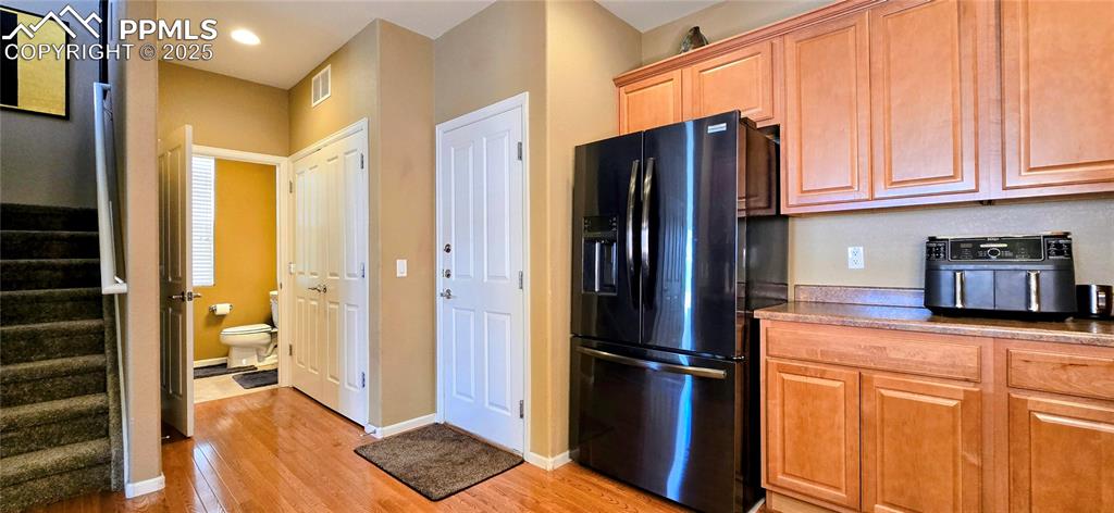 Image 12 of 37: Kitchen with black refrigerator with ice dispenser, light wood-type floorin