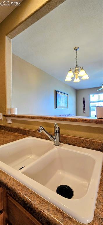 Image 13 of 37: Kitchen view of dark countertops and hanging light fixtures