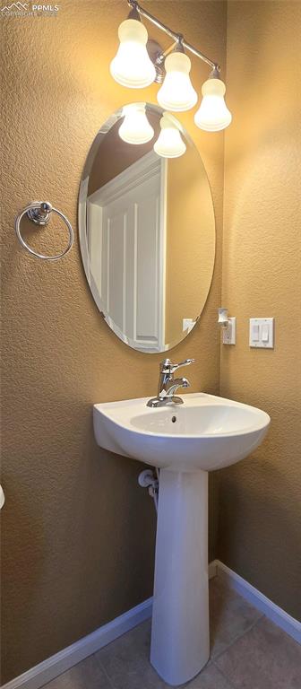 Image 14 of 37: Bathroom featuring a textured wall and tile patterned floors