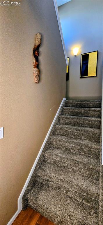 Image 16 of 37: Staircase featuring baseboards and wood finished floors