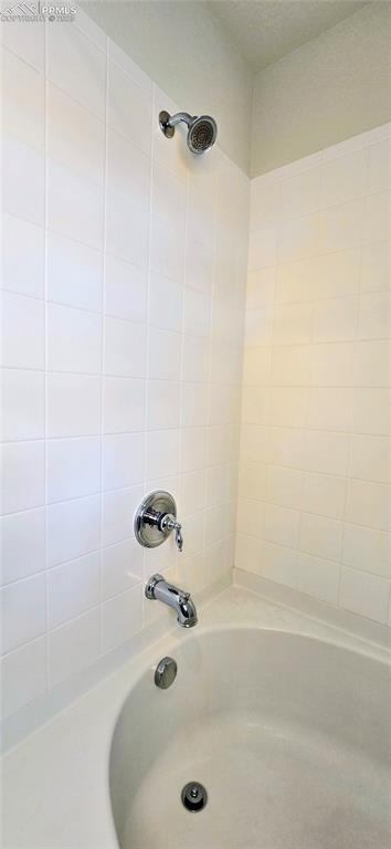 Image 31 of 37: Bathroom featuring washtub / shower combination