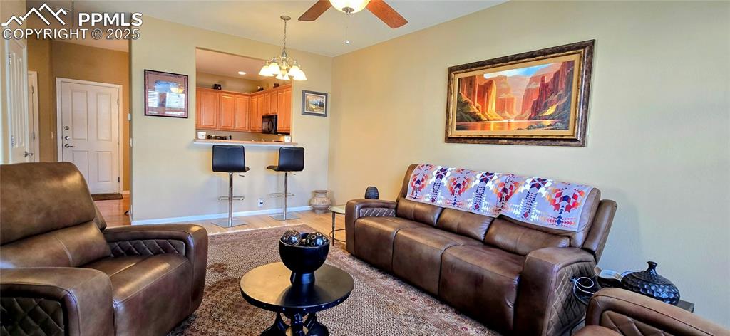 Image 5 of 37: Living room featuring light wood-type flooring, a chandelier, and a ceiling