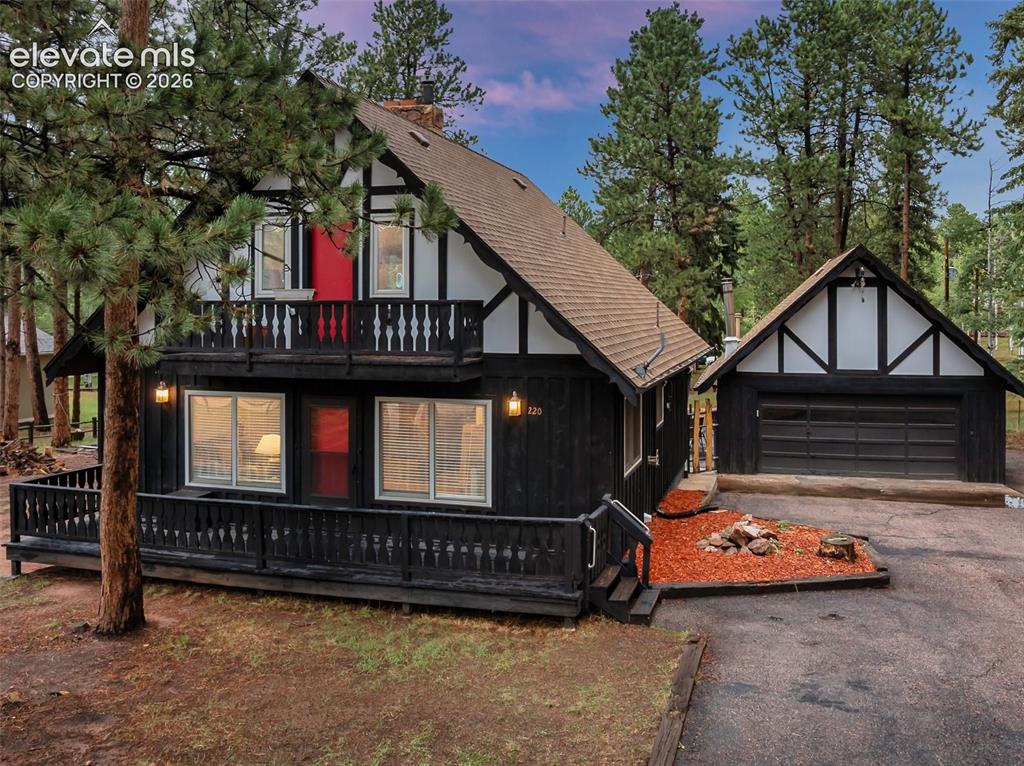 Image 1 of 40: Tudor-style exterior with black siding and white trim, featuring an upper-l