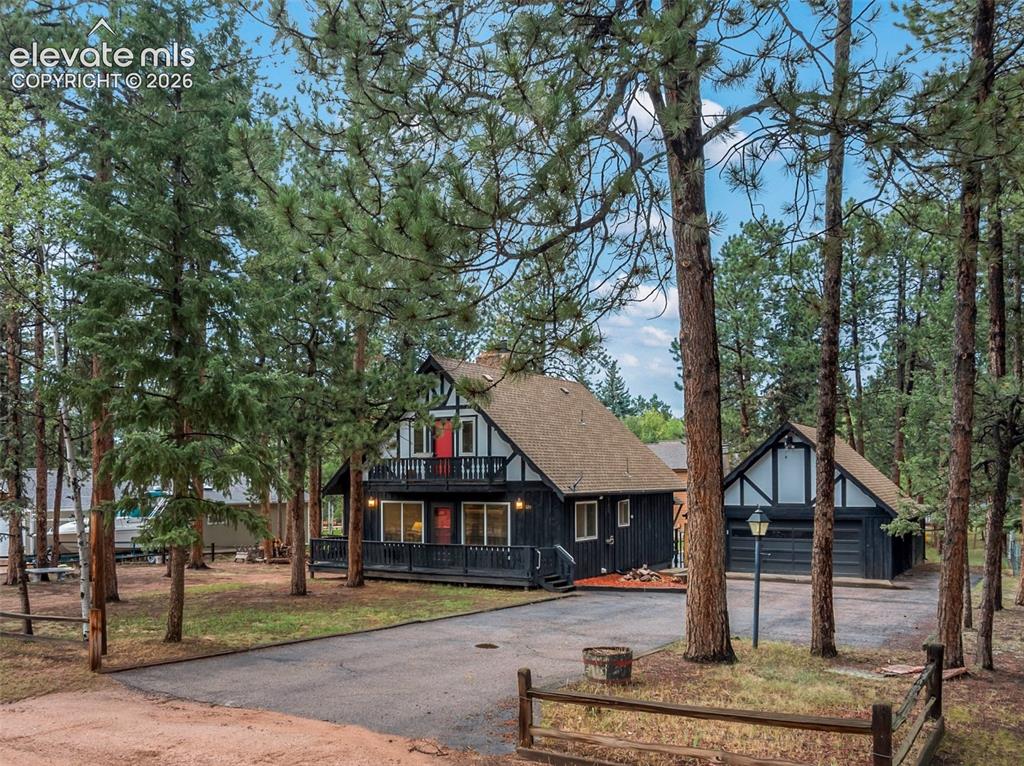 Image 10 of 40: Exterior featuring a large attached balcony, dark wood siding, a prominent 