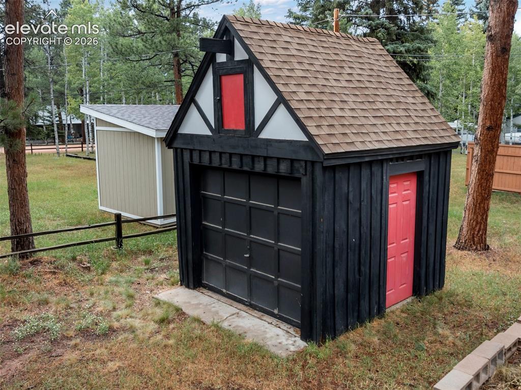 Image 14 of 40: Two distinct outbuildings, one featuring a vertical wood plank exterior wit