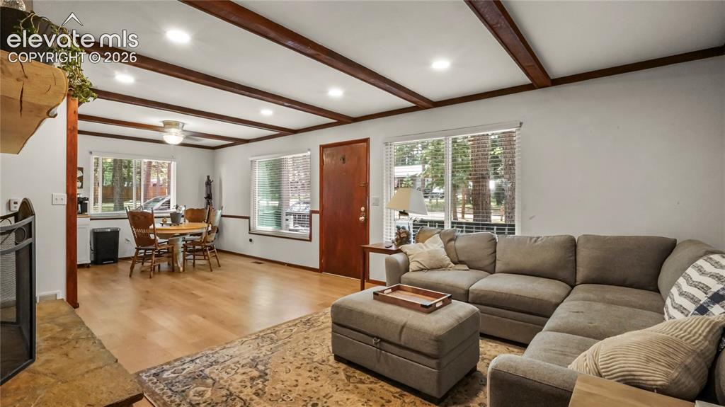 Image 17 of 40: Exposed wood beam ceiling, recessed lighting, LVP flooring, multiple window