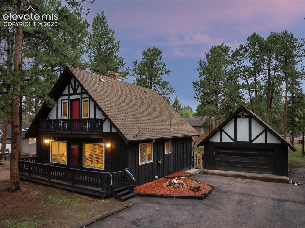 Image 2 of 40: Chalet-style exterior with dark siding and white trim, featuring a prominen