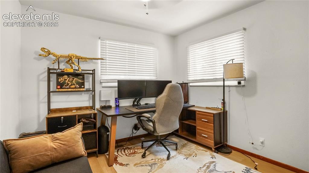 Image 21 of 40: Main floor bedroom or office, LVP flooring, and white window blinds