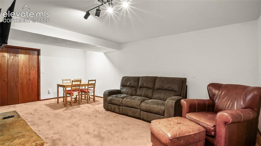 Image 23 of 40: Recessed track lighting and wall-mounted television, carpet