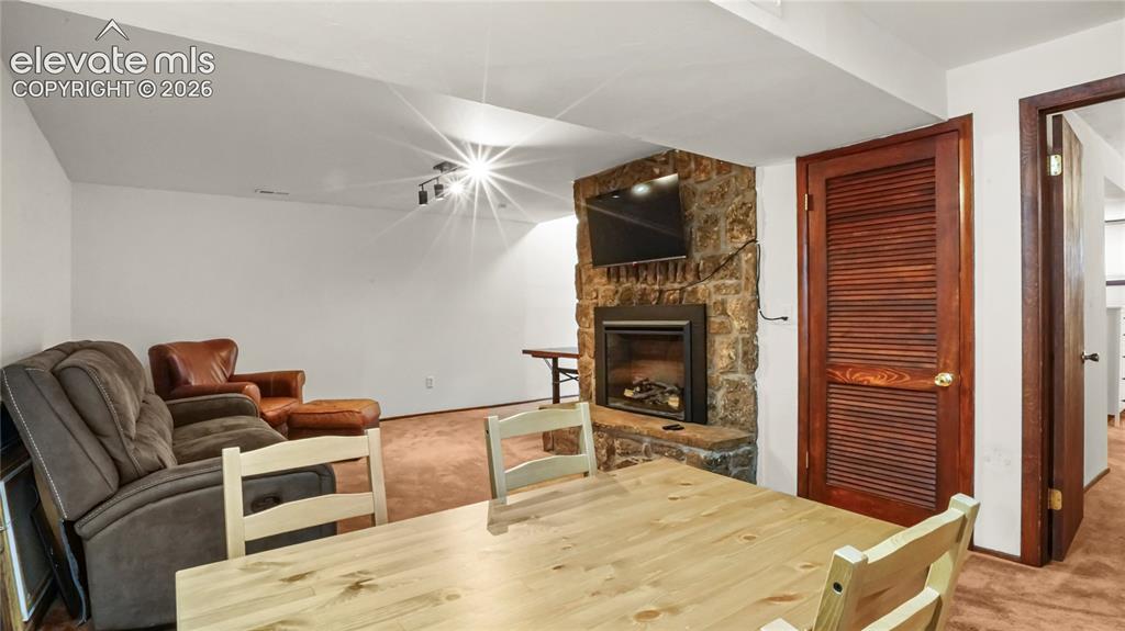 Image 25 of 40: Basement showing a separate table with the fireplace.