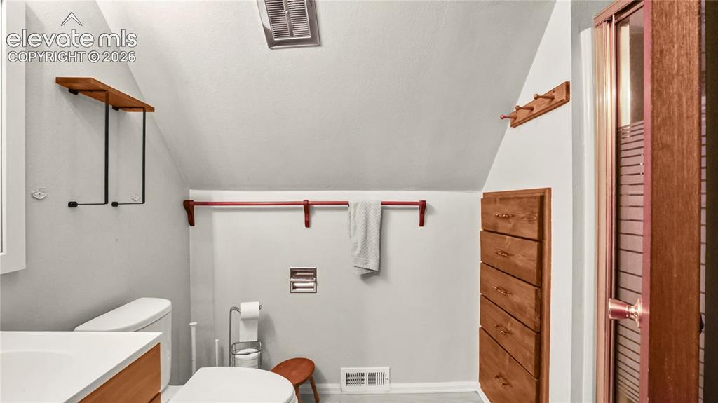 Image 29 of 40: Upstairs bathroom, with vanity, toilet and shower, angled ceiling with a re