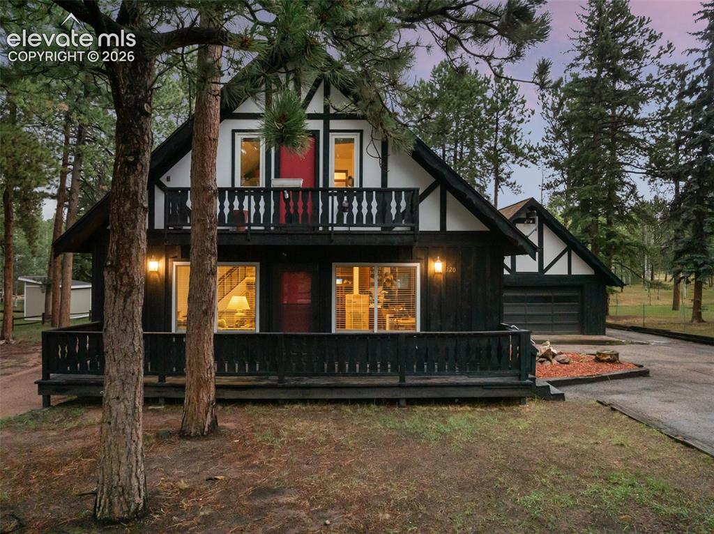 Image 5 of 40: Tudor-style exterior with black siding and white trim, featuring a ground-l