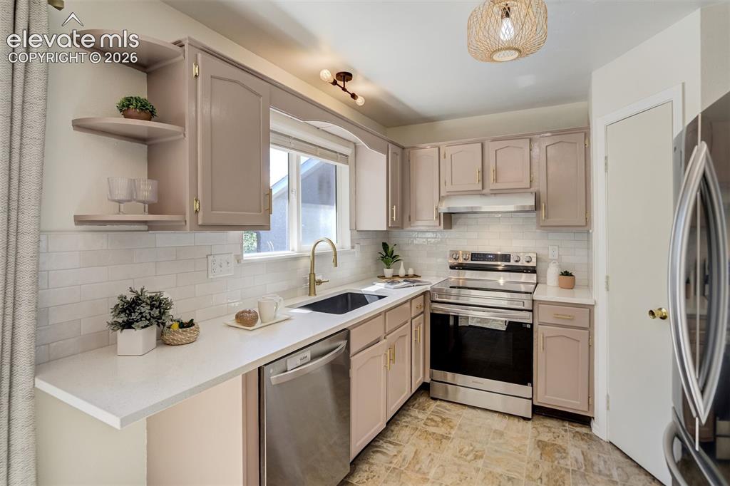 Image 10 of 39: Quartz counters, tile backsplash, and new appliances. 