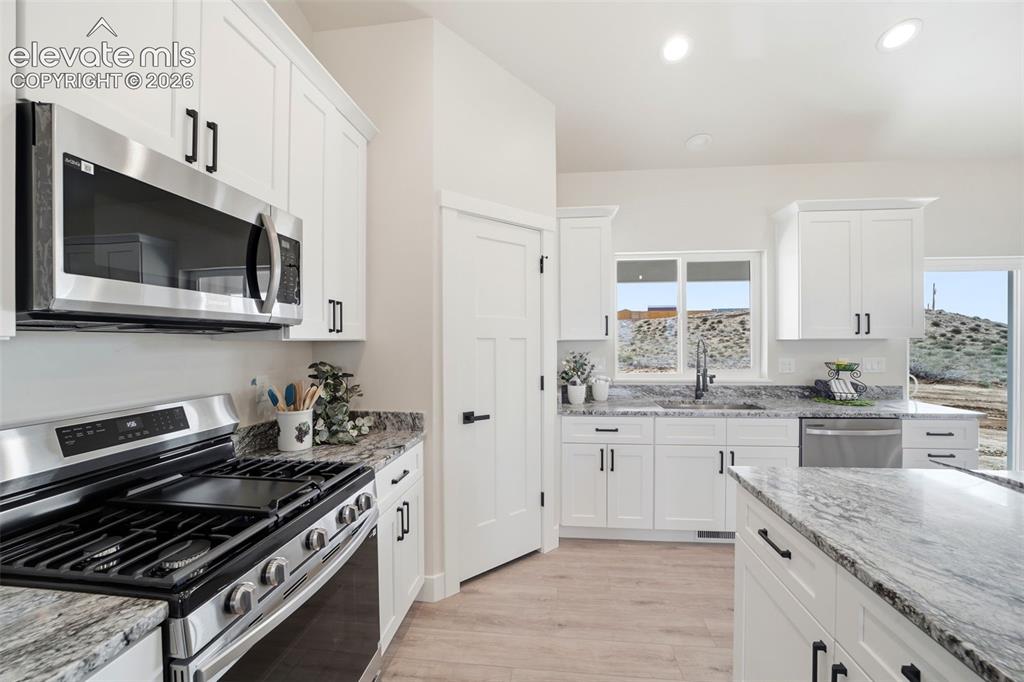 Image 10 of 26: Kitchen and Island with hard surfaces and steel appliances
