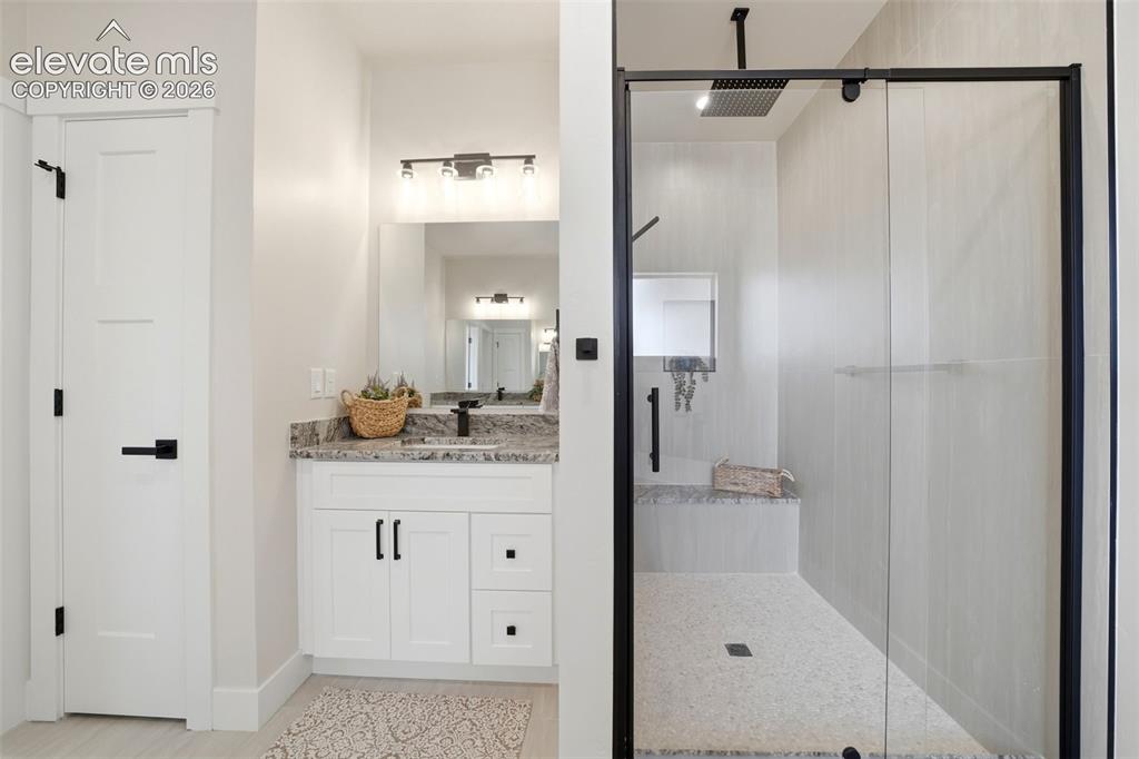 Image 18 of 26: Primary Bath, 2nd vanity and walk in shower with bench.