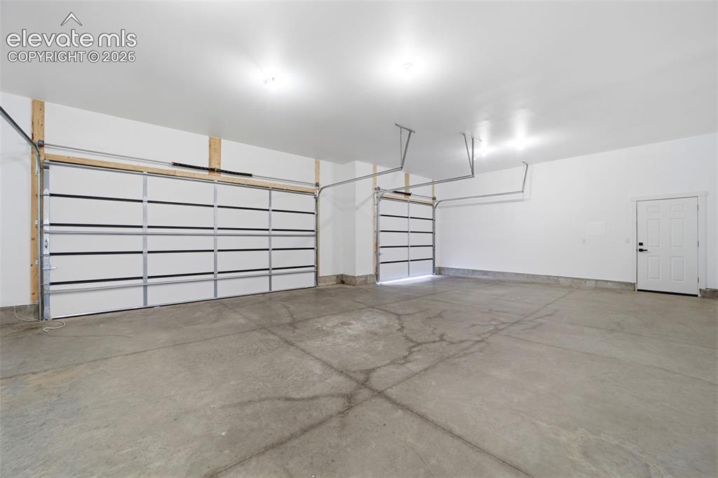 Image 24 of 26: 3 car garage drywalled walls