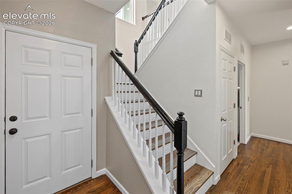 Image 10 of 50: Entry with Hardwood floors and open stairway with hardwood