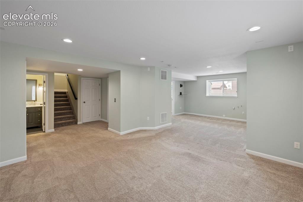 Image 24 of 50: Large basement family room with tons of natural light