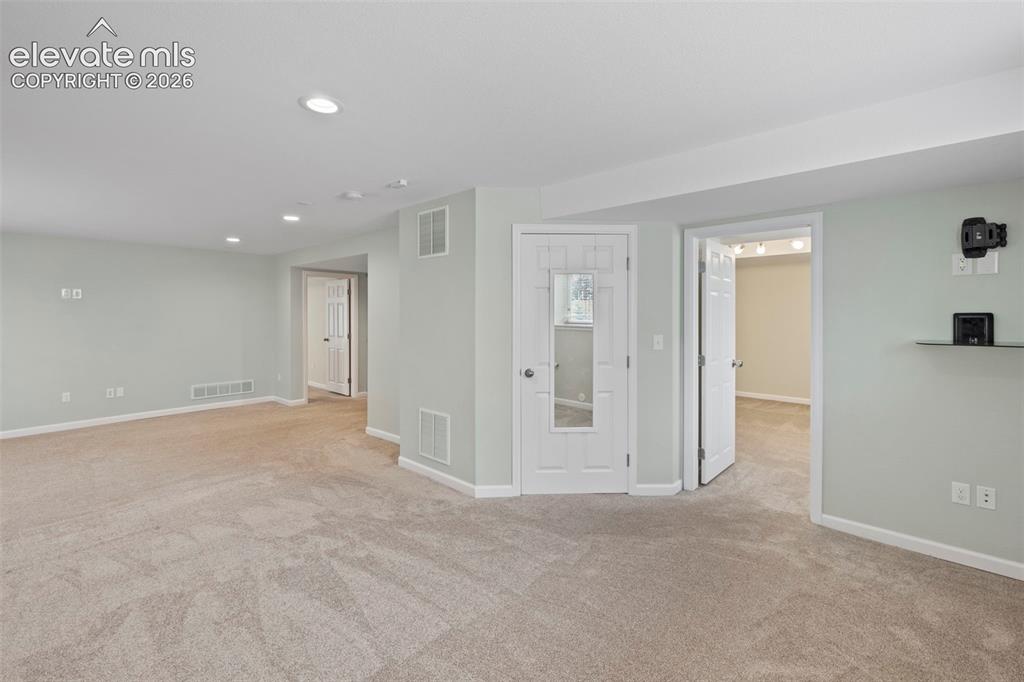 Image 26 of 50: Large basement family room with tons of natural light