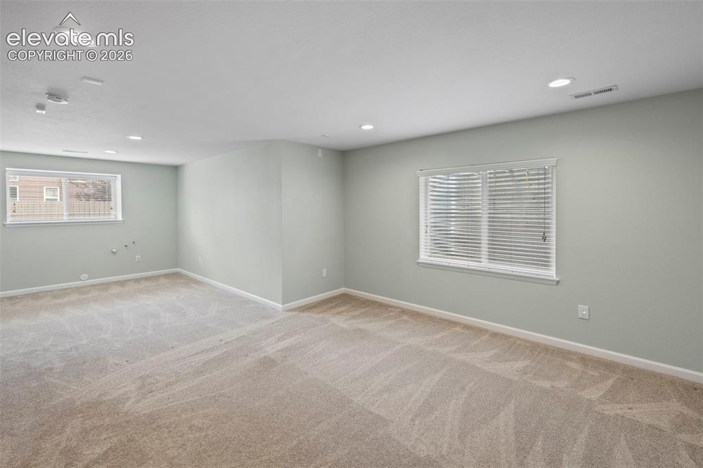 Image 27 of 50: Large basement family room with tons of natural light