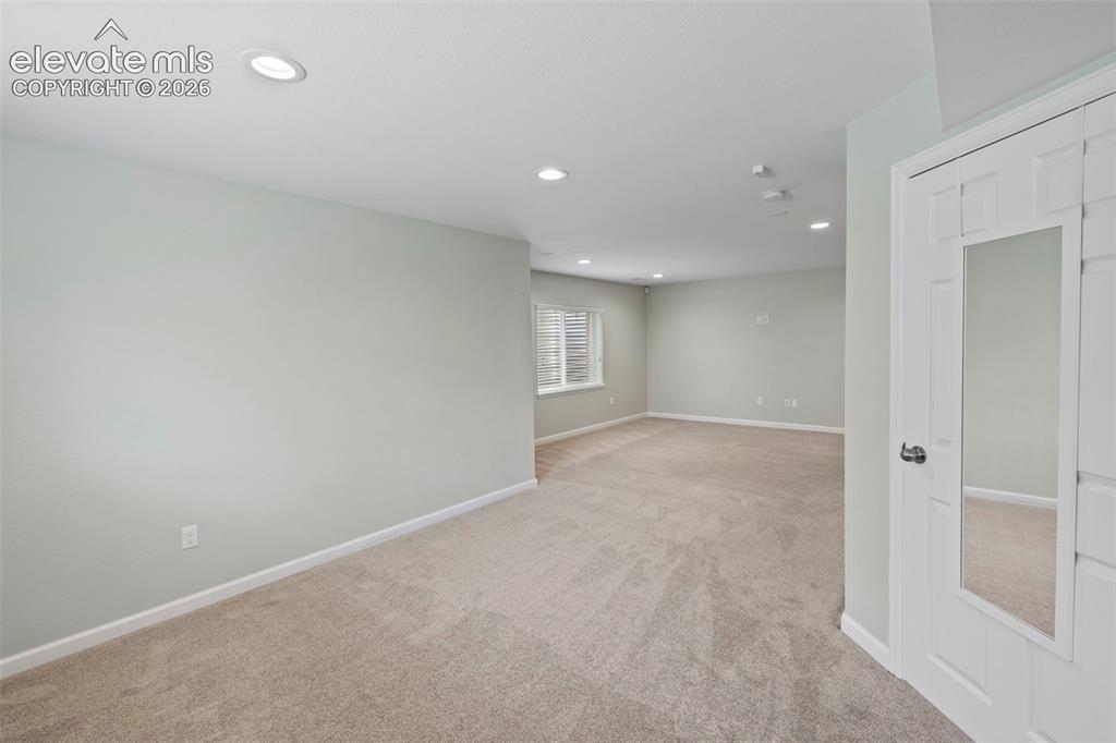 Image 28 of 50: Large basement family room with tons of natural light