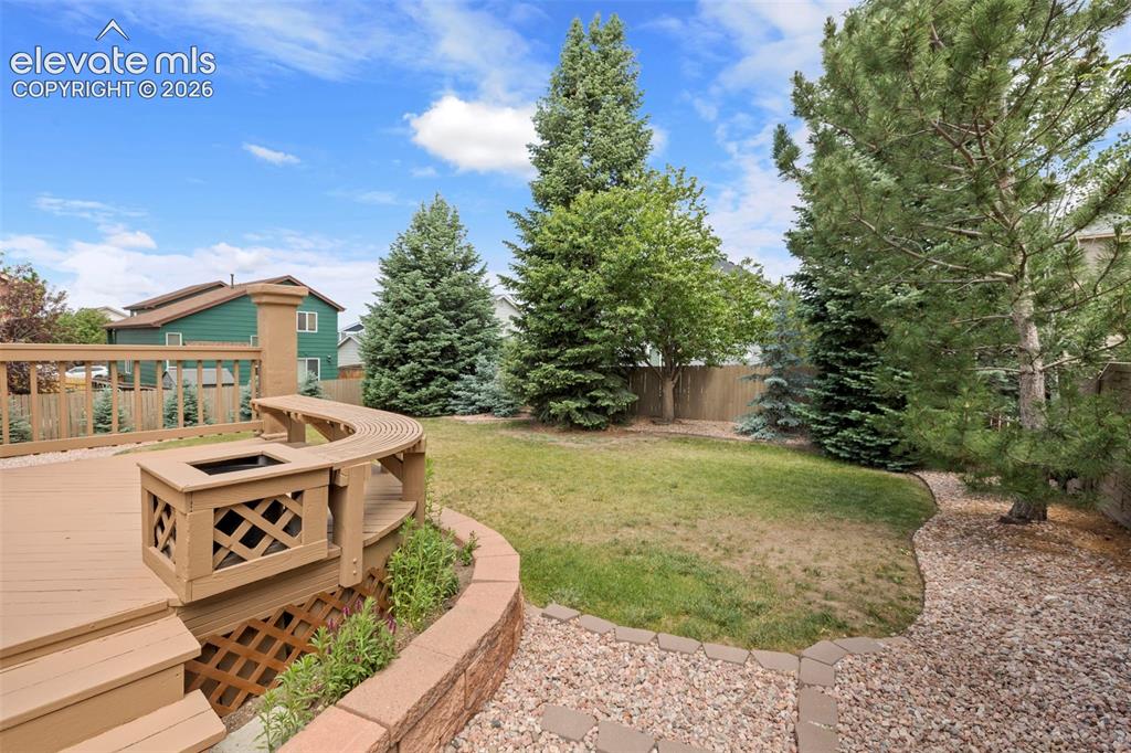 Image 34 of 50: Deck with seating opens to the private and large backyard