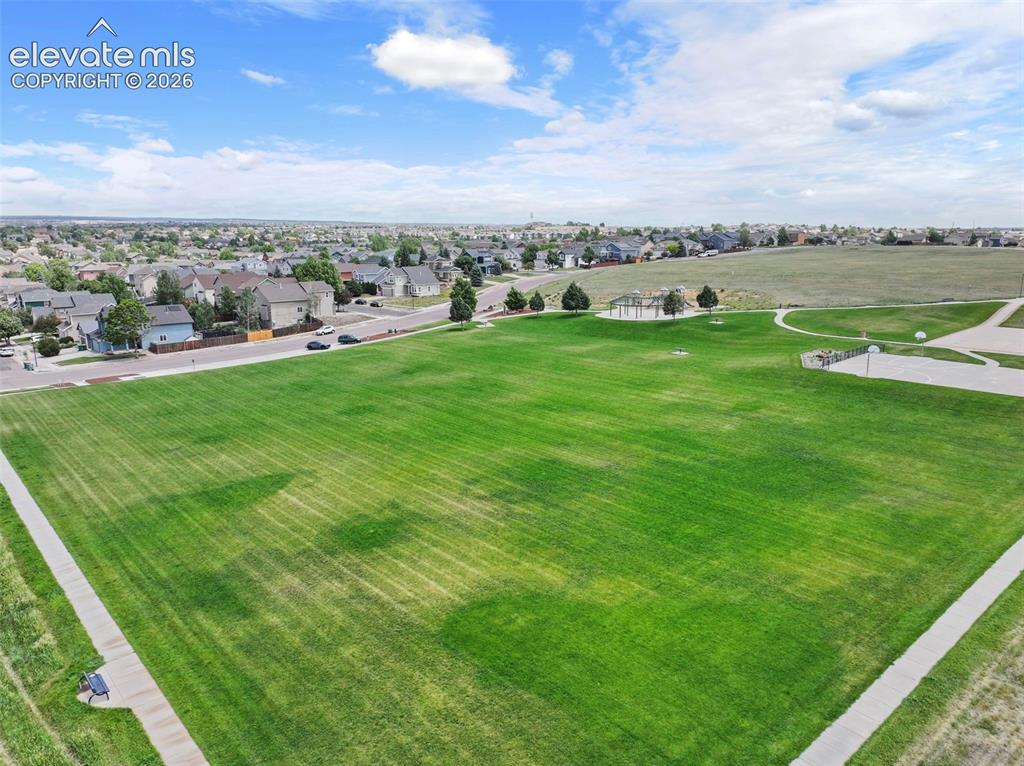 Image 49 of 50: Park with walking paths, playground, skate park, and open space