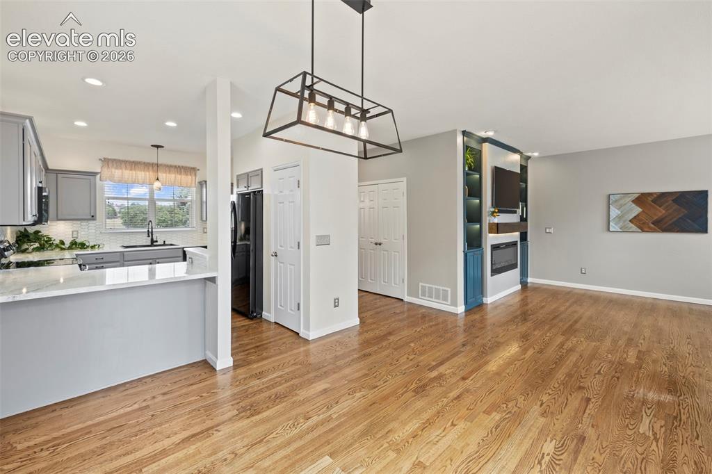 Image 6 of 50: Dining Room with hardwood floors, updated light fixtures and walk-out to th