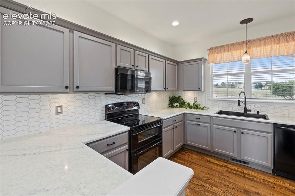 Image 7 of 50: Kitchen with beautiful hardwood floors, under cabinet lighting, epoxied cou