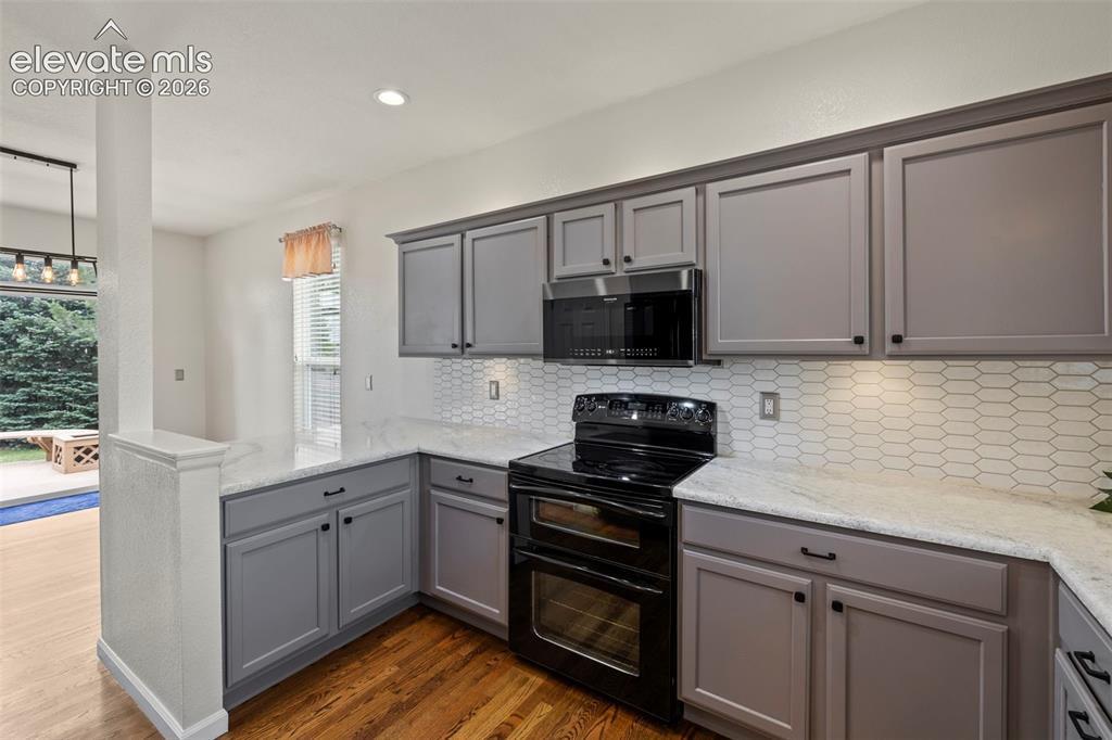 Image 8 of 50: Kitchen with beautiful hardwood floors, under cabinet lighting, epoxied cou