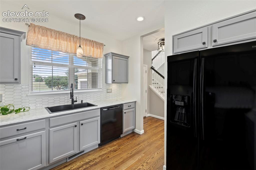 Image 9 of 50: Kitchen with beautiful hardwood floors, under cabinet lighting, epoxied cou