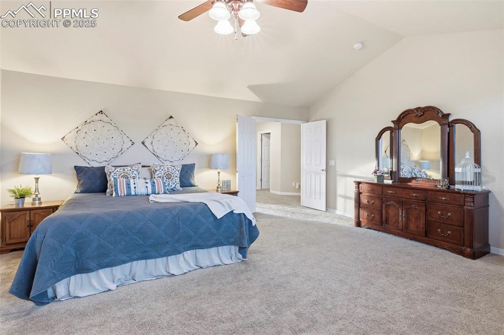 Image 20 of 46: Bedroom featuring light carpet, lofted ceiling, and ceiling fan