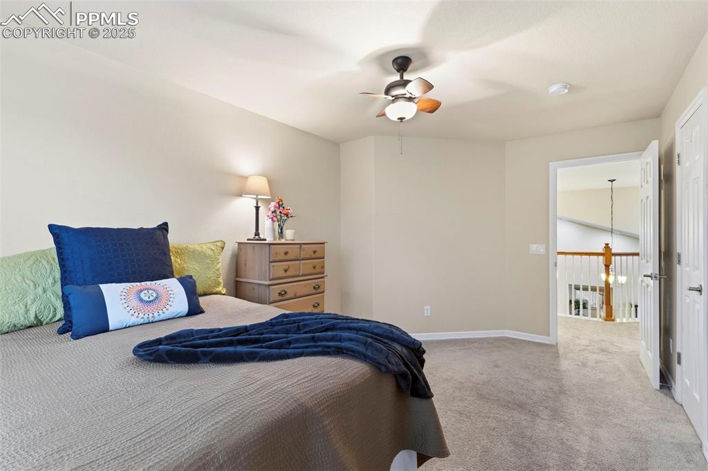 Image 29 of 46: Bedroom with light colored carpet and a ceiling fan