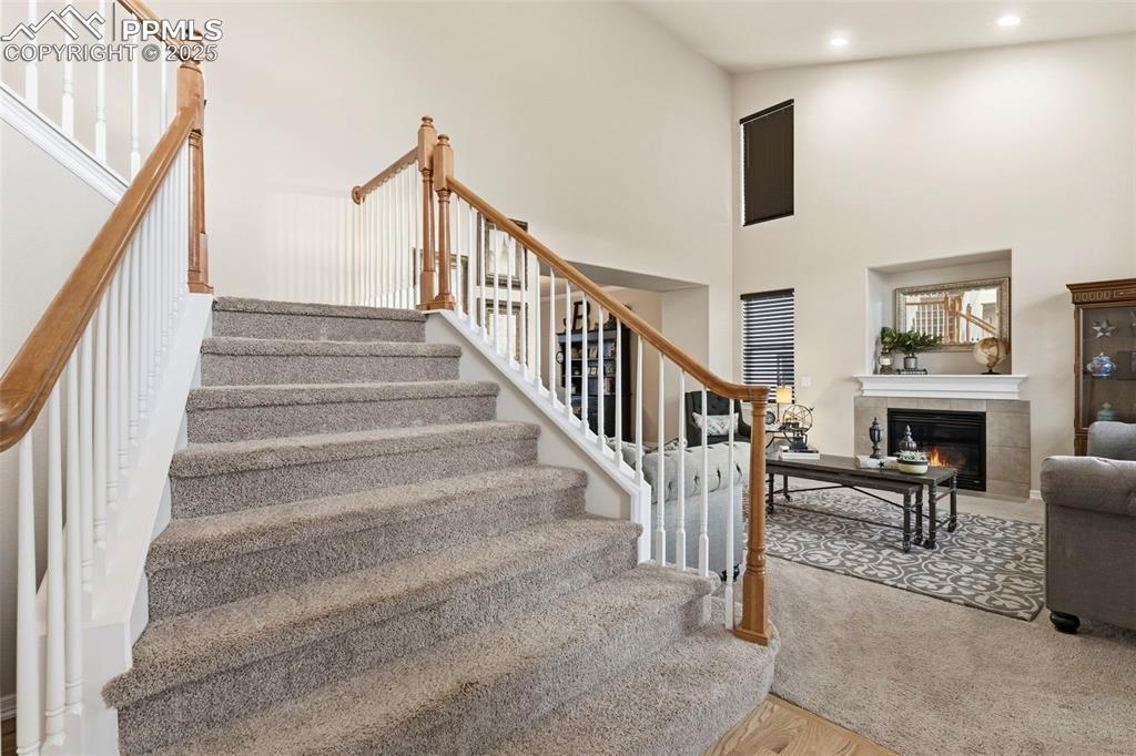 Image 3 of 46: A grand entry and open staircase featuring a towering ceiling, carpet floor