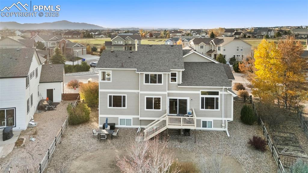 Image 39 of 46: Rear view of property with a deck, roof with shingles, and a residential vi