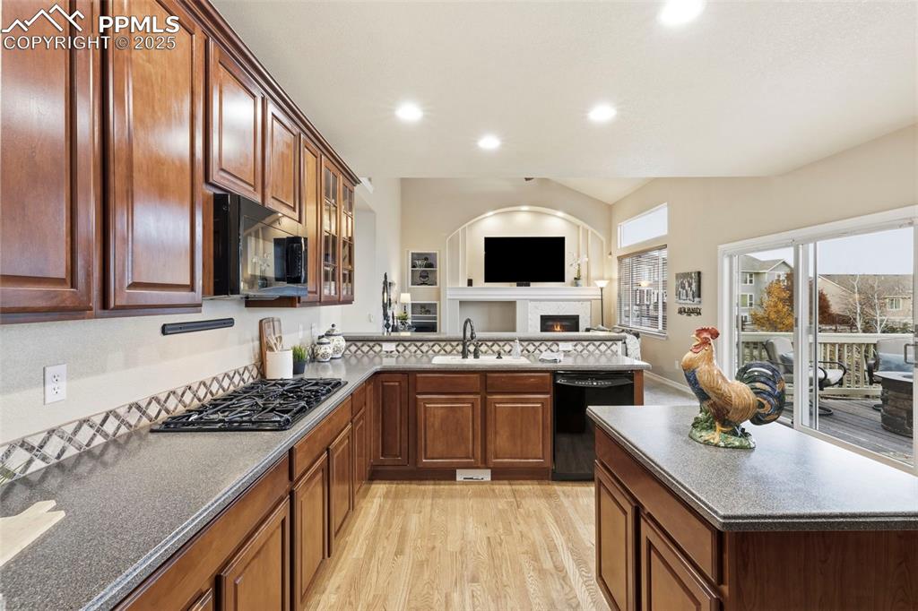 Image 5 of 46: Kitchen with light wood-style flooring, black appliances, recessed lighting