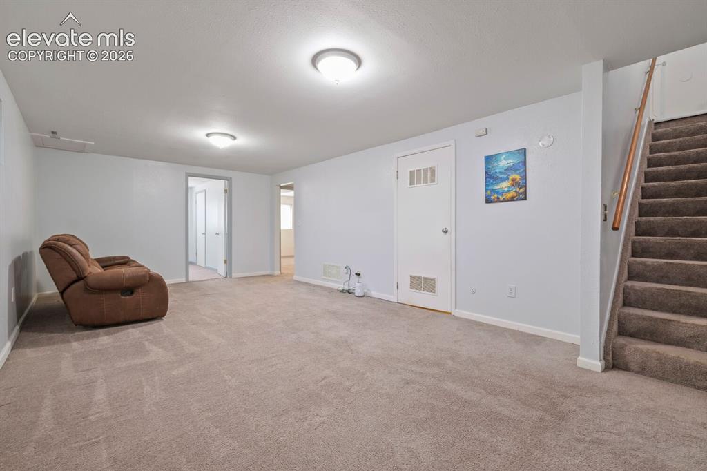 Image 11 of 26: Spacious carpeted room featuring white walls, flush-mount ceiling lighting,